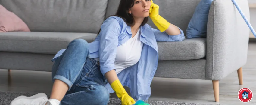 HHC - A sad woman sitting on carpet surrounded by cleaning tools