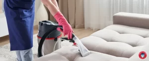 HHC - Woman cleaning couch with vacuum cleaner
